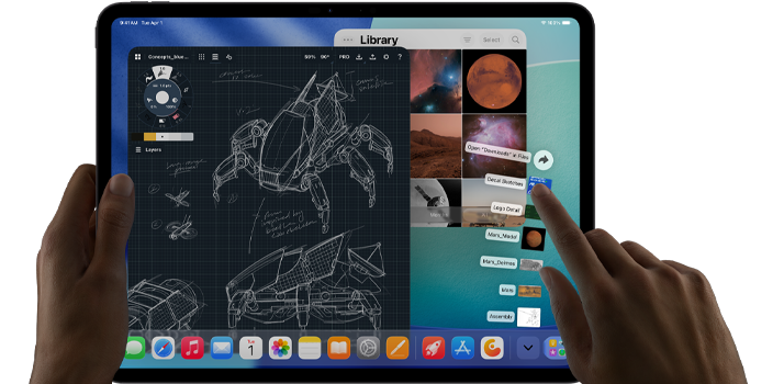 iPad Pro, space black color, left hand holding device, right hand pointing gesturing to manipulate multiple open app windows, a drawing app with sketches of mechanical designs, photos library of planets and space https://external.webstorage.gr/new-ipad-pdp/images, downloads folder files fanned out