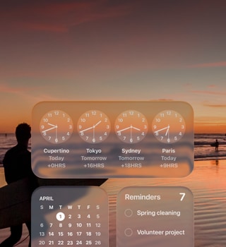 Liquid Glass Clock, Calendar, Reminders, and Weather widgets on macOS Tahoe screen over a scene of a surfer walking on the beach at sunset